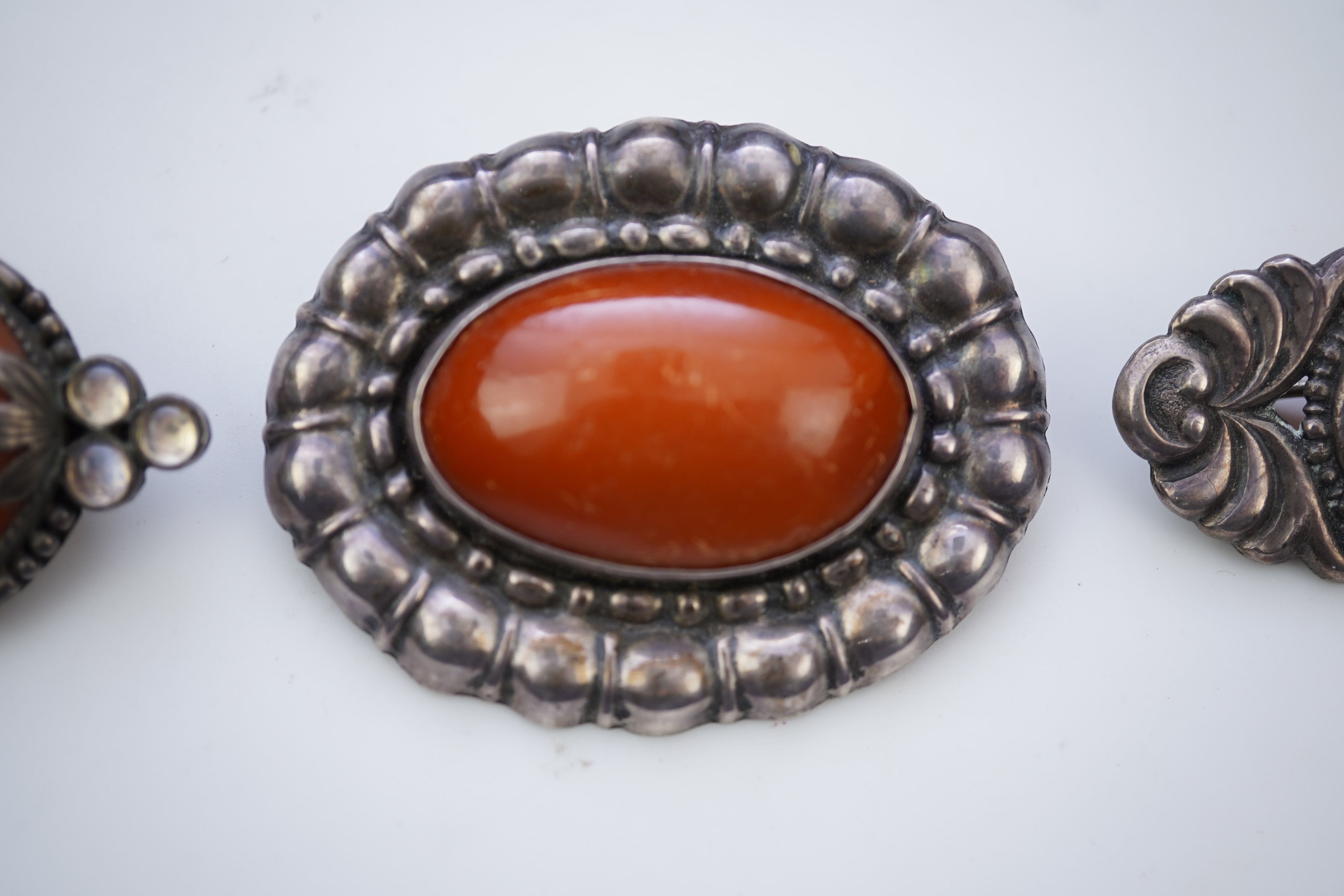Three Arts & Crafts silver and amber brooches, early 20th century
